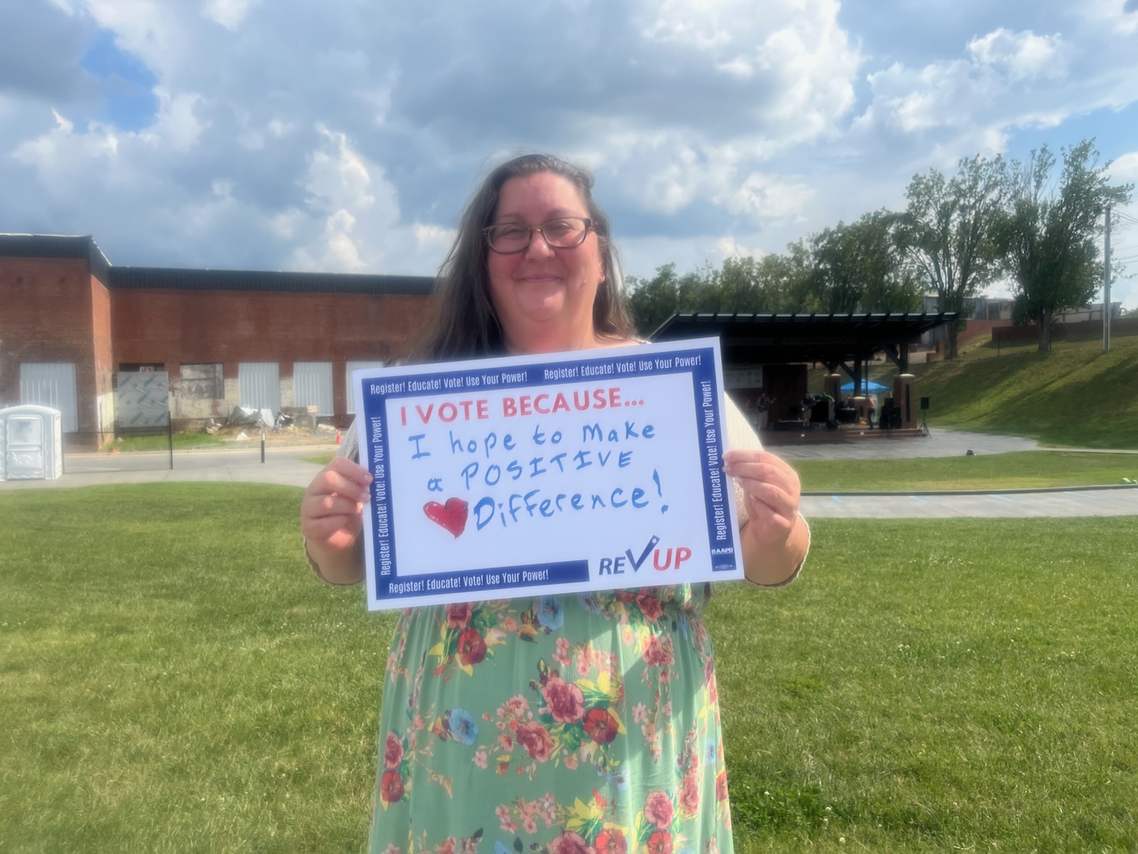 Felicia Dreher holding a sign that reads 'I vote because I hope to make a positive difference'